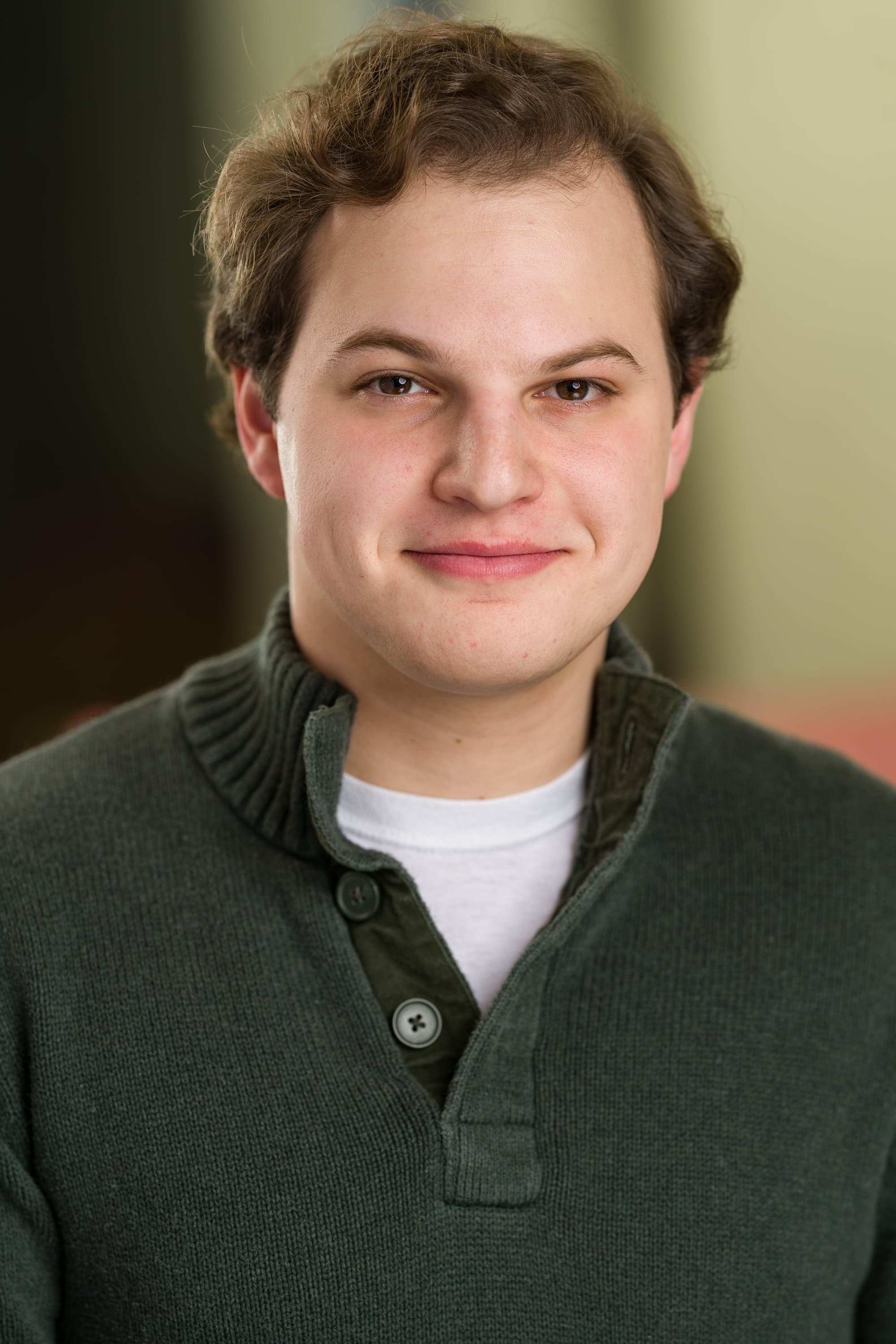 Jacob in green sweater, smirking.